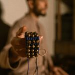 Close-up of a male hand holding traditional Indian ghungroo anklet, blurred background